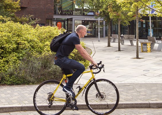 Student cycling outside University of Exeter's campus